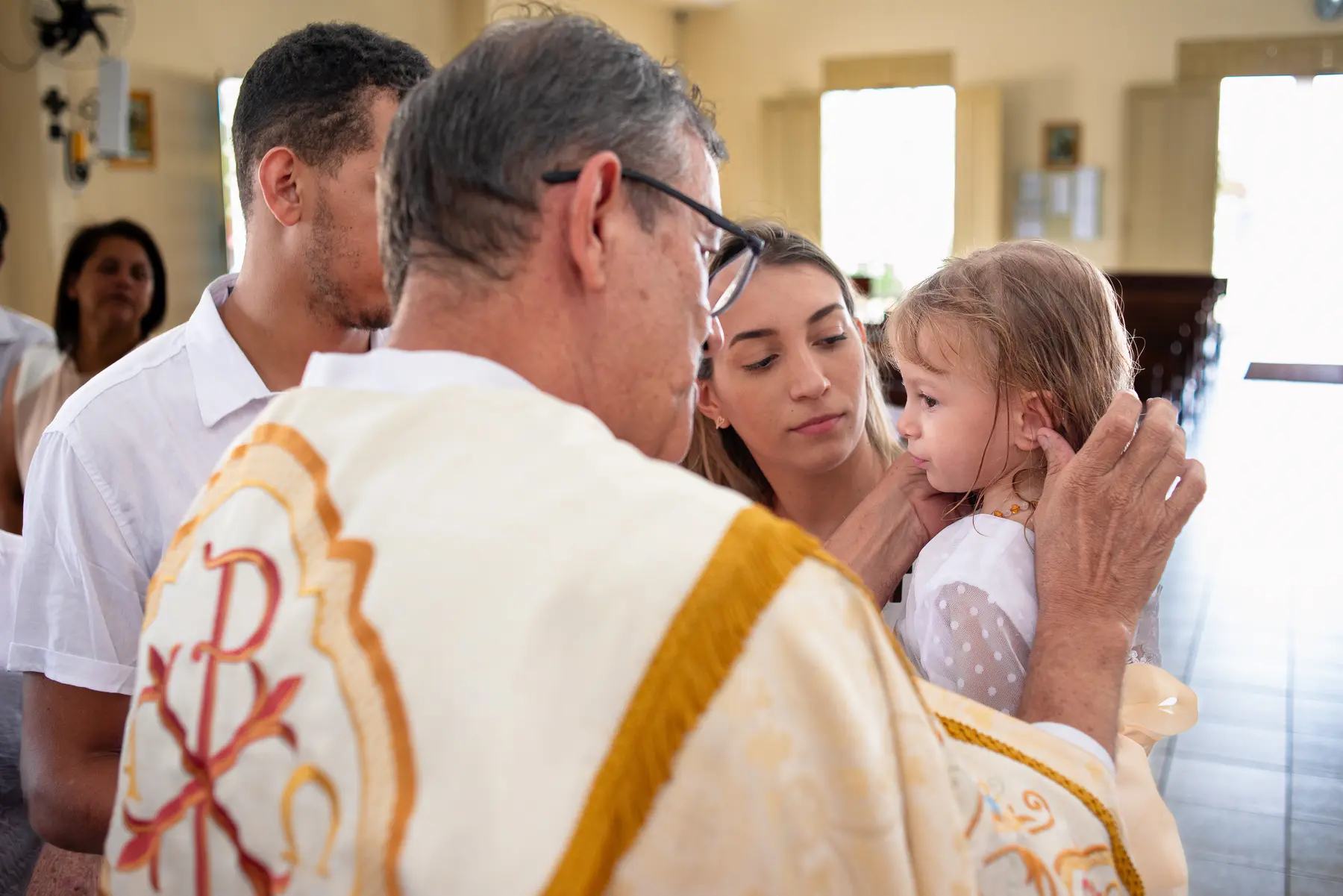 Adylla recebendo a bênção durante o batizado na Paróquia Nossa Senhora de Fátima, em Caruaru