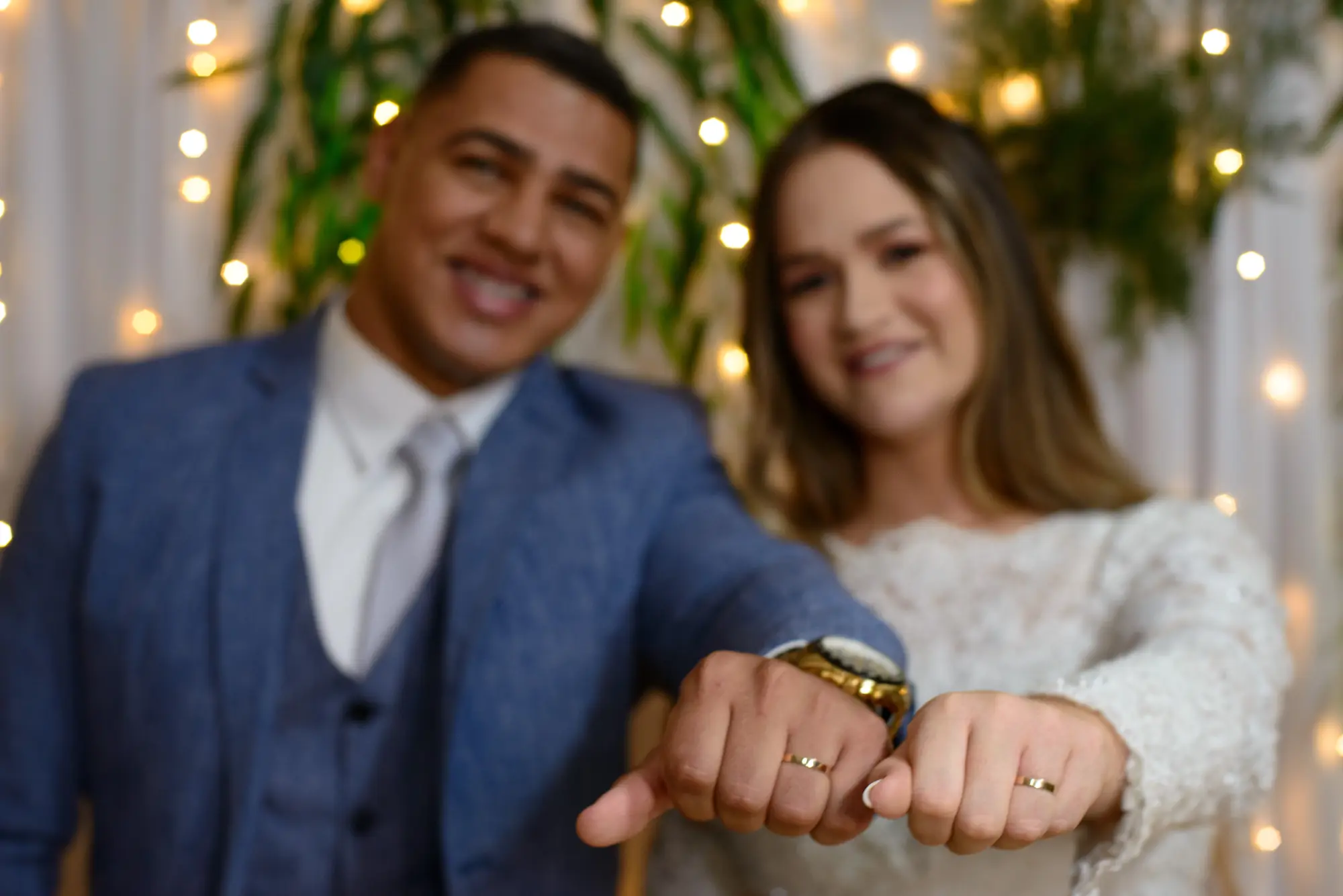 Alianças em primeiro plano com o casal ao fundo