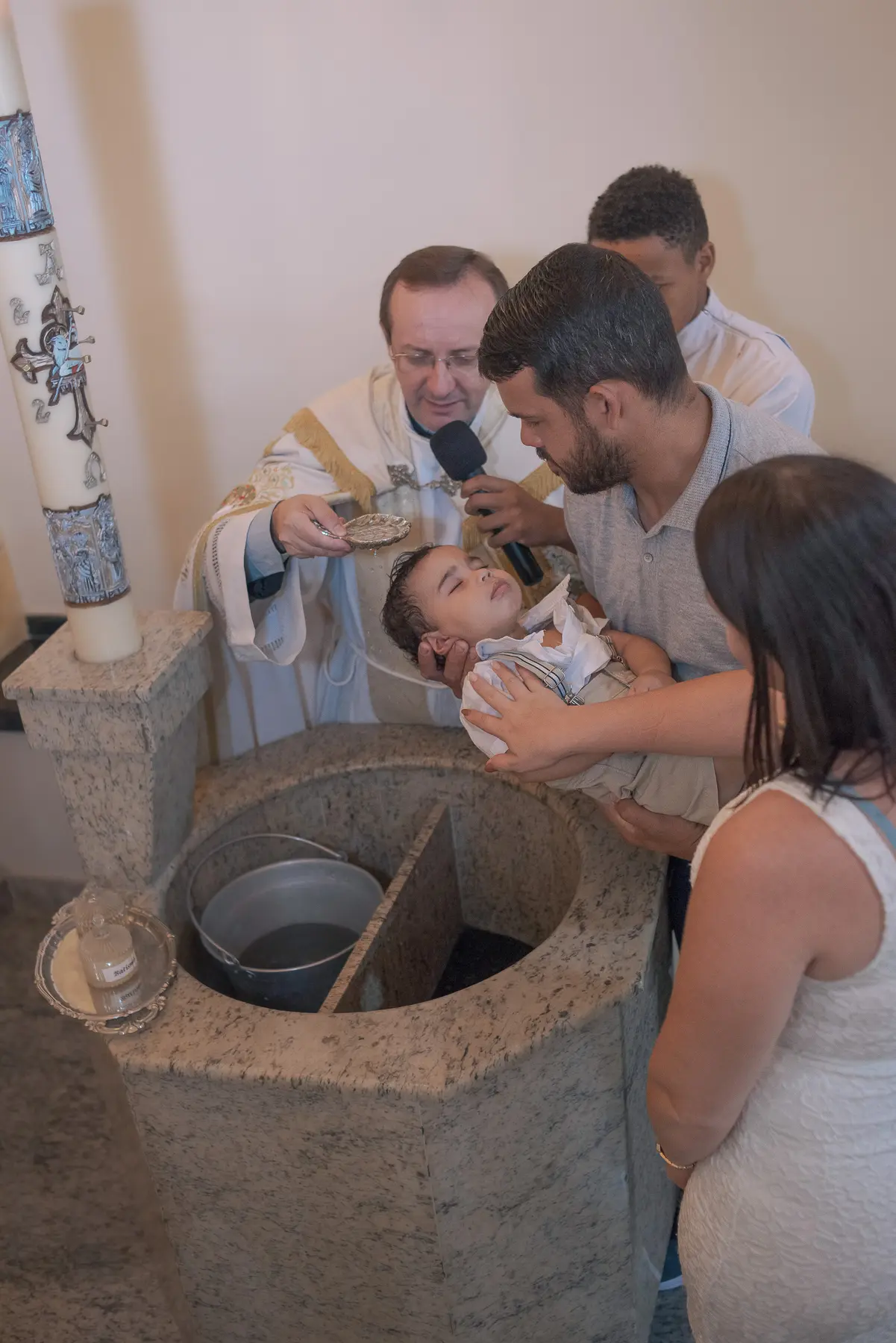 Criança recebendo a água do batismo na Paróquia Nossa Senhora de Fátima, em Caruaru