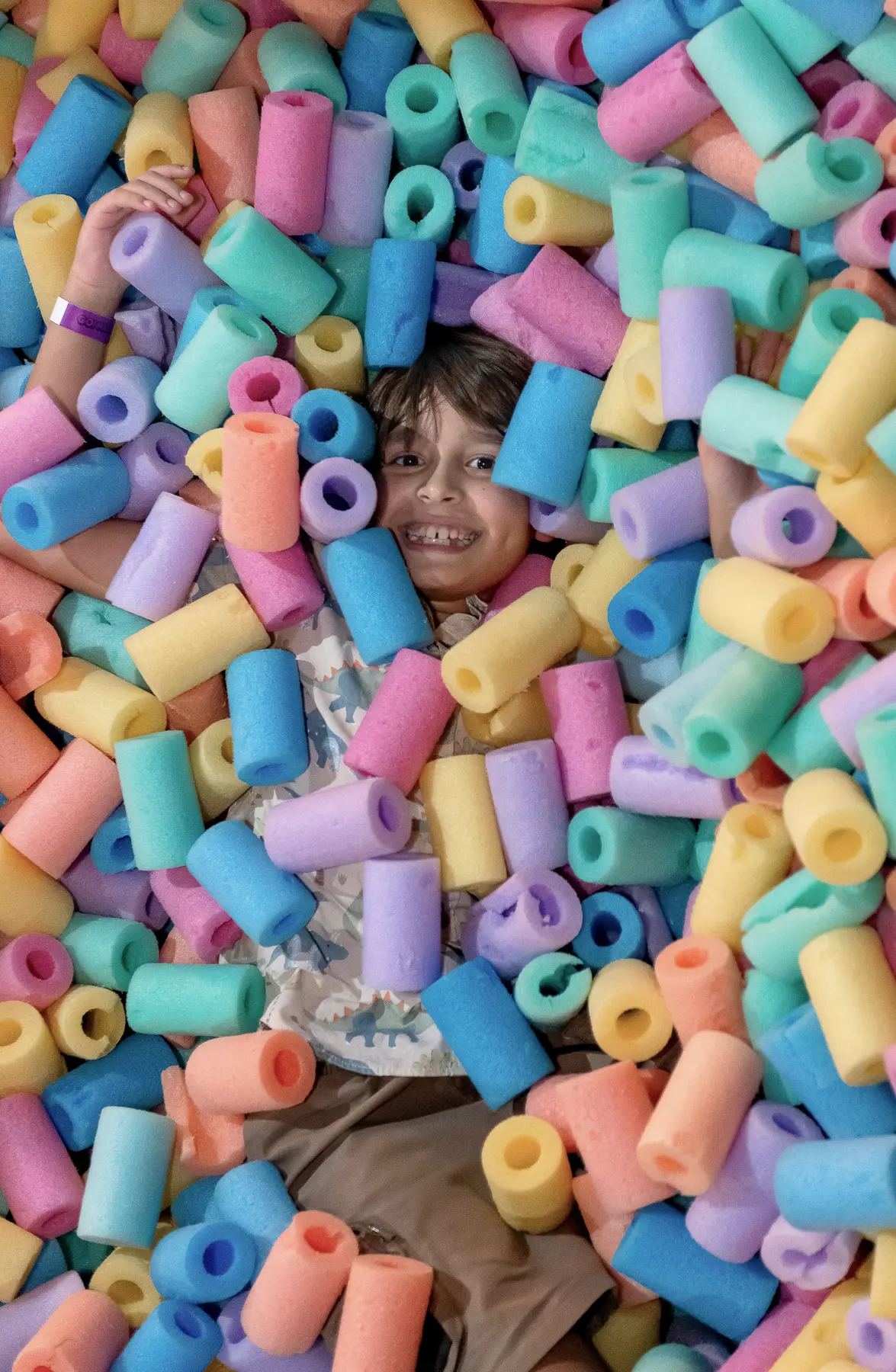 Criança brincando em uma piscina de blocos coloridos