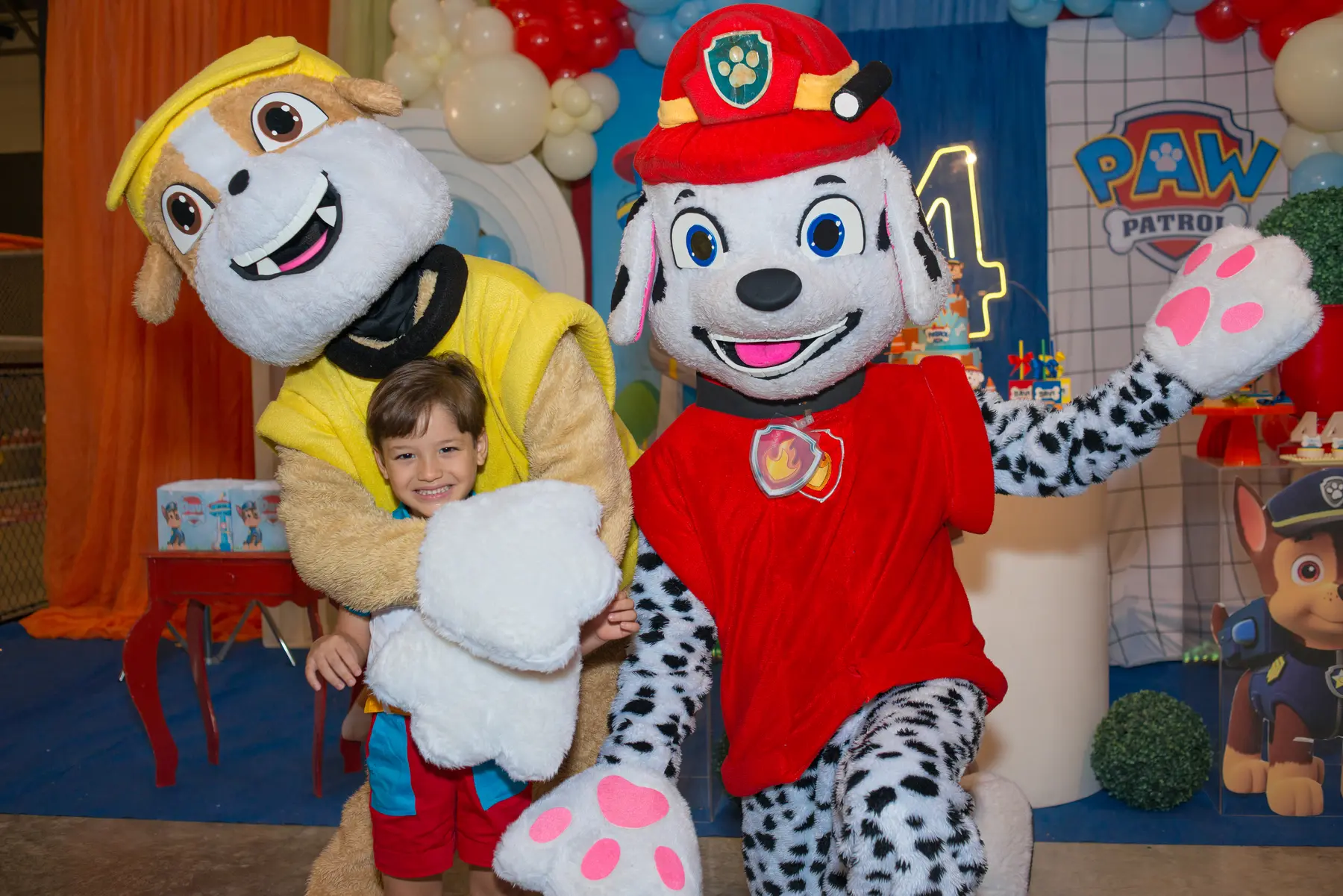 Davi sorrindo com os personagens de sua festa