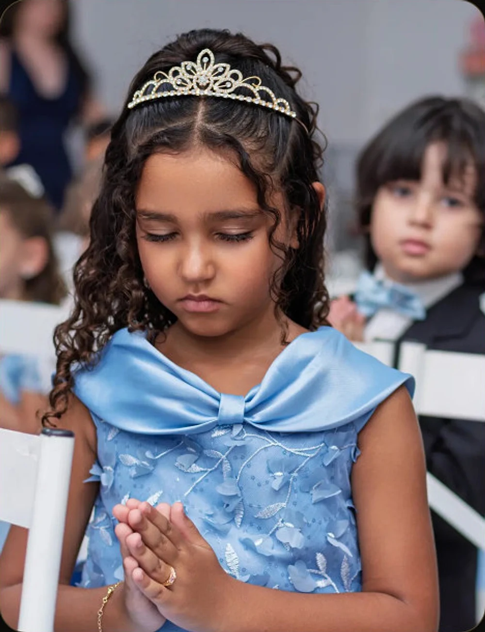 Formanda em oração durante a cerimônia de formatura infantil