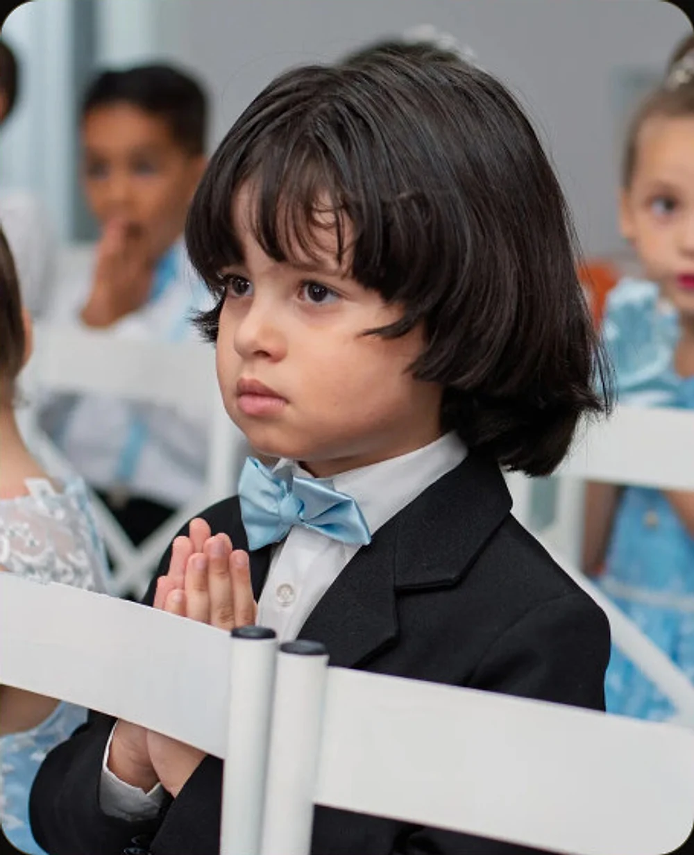 Criança acompanhando a oração durante a formatura do ABC