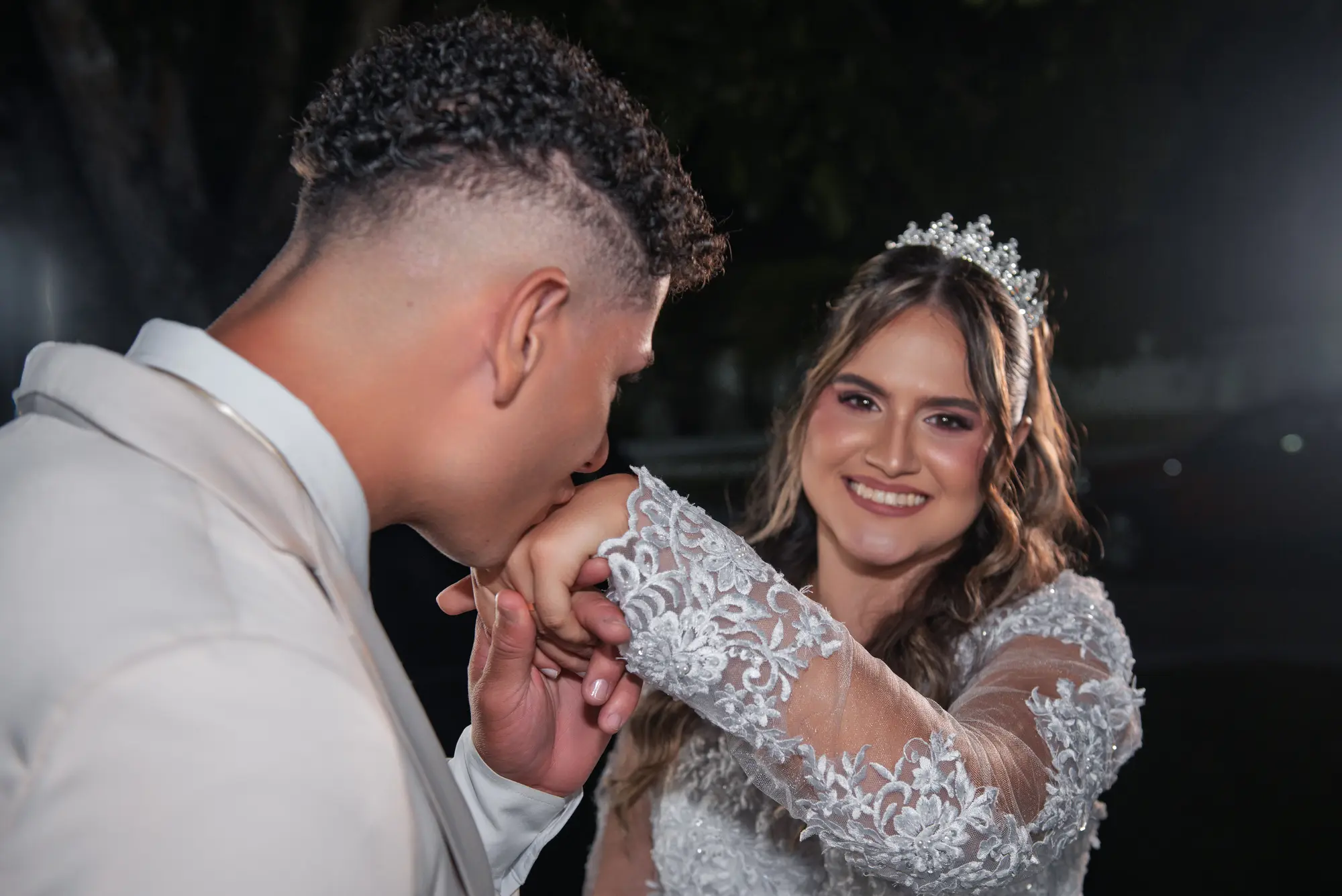 Noivo beijando a mão da noiva em um gesto de carinho