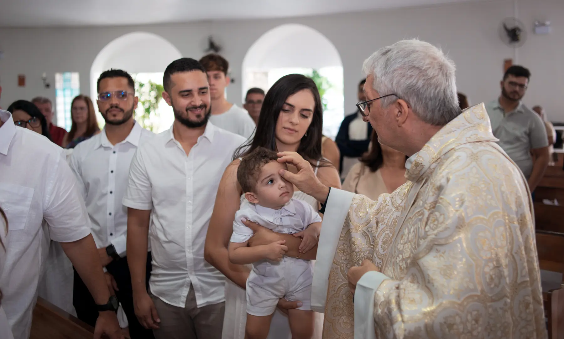 Heitor recebendo a bênção do padre na Igreja da Natividade, em Caruaru
