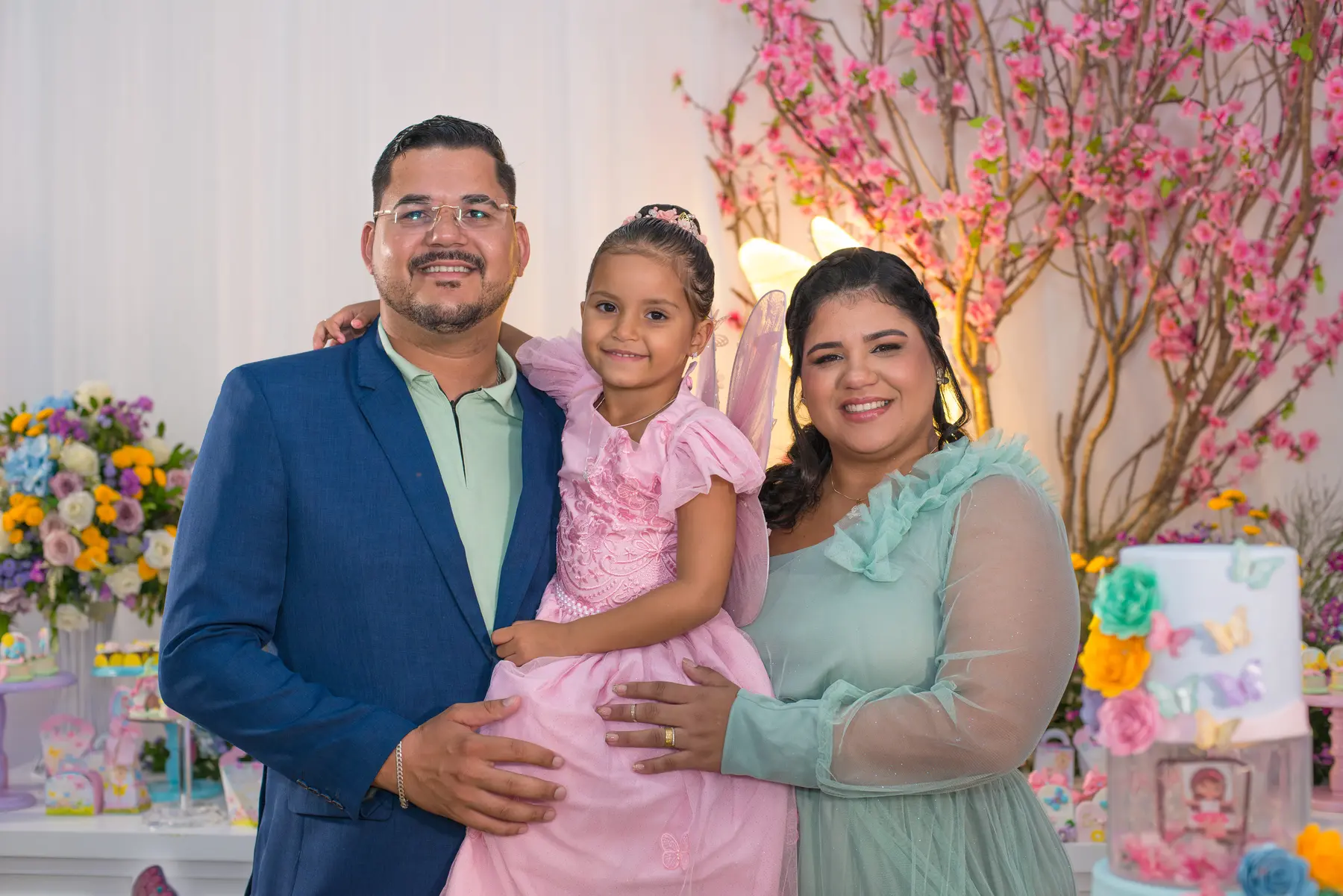 Heloisa reunida com os pais diante da decoração