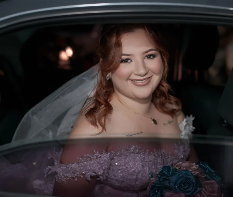 Noiva sorrindo dentro do carro antes da cerimônia de casamento.