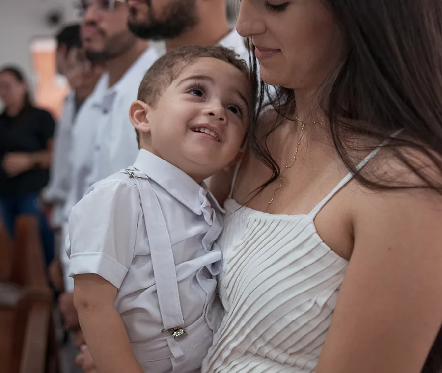 Família em momento afetuoso durante o batizado.