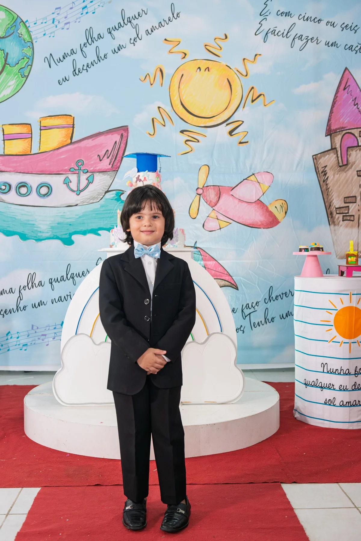 Isaac em retrato no cenário da cerimônia de formatura infantil