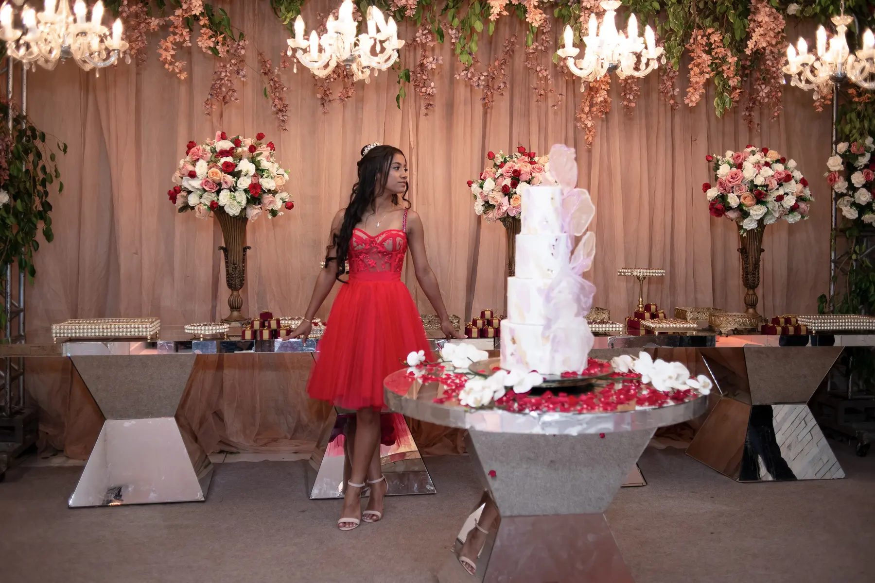 Lizandra diante do bolo e da decoração de sua festa de 15 anos