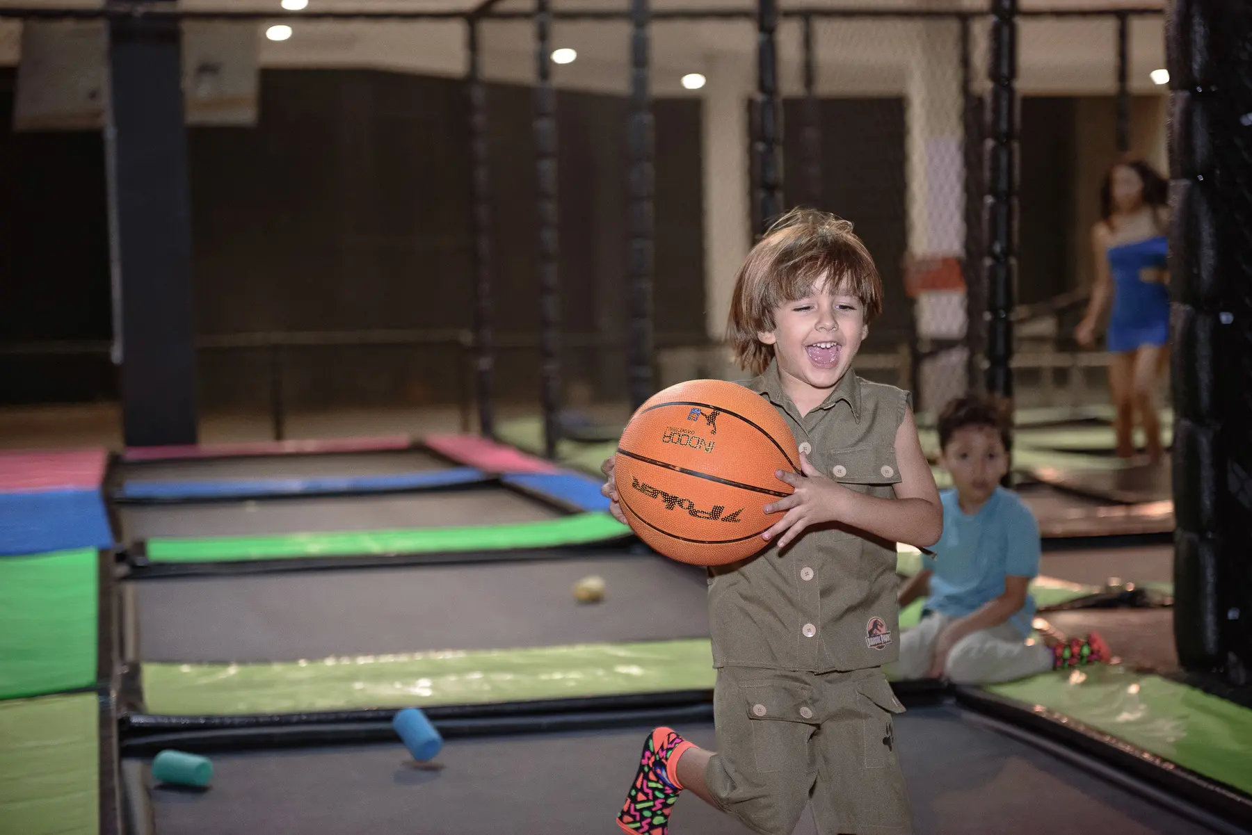 Menino sorrindo enquanto corre com uma bola de basquete durante uma festa infantil