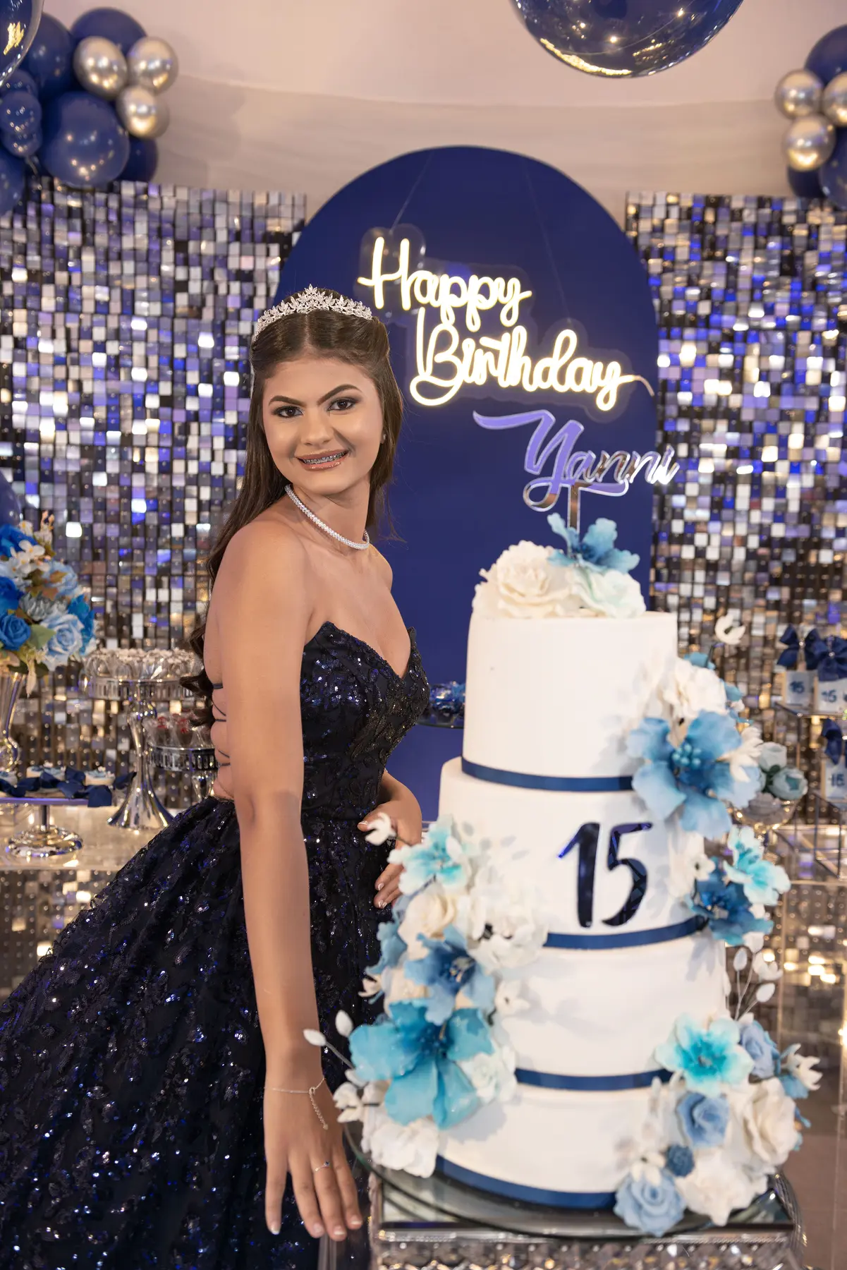 Yanni ao lado do bolo em sua festa de 15 anos