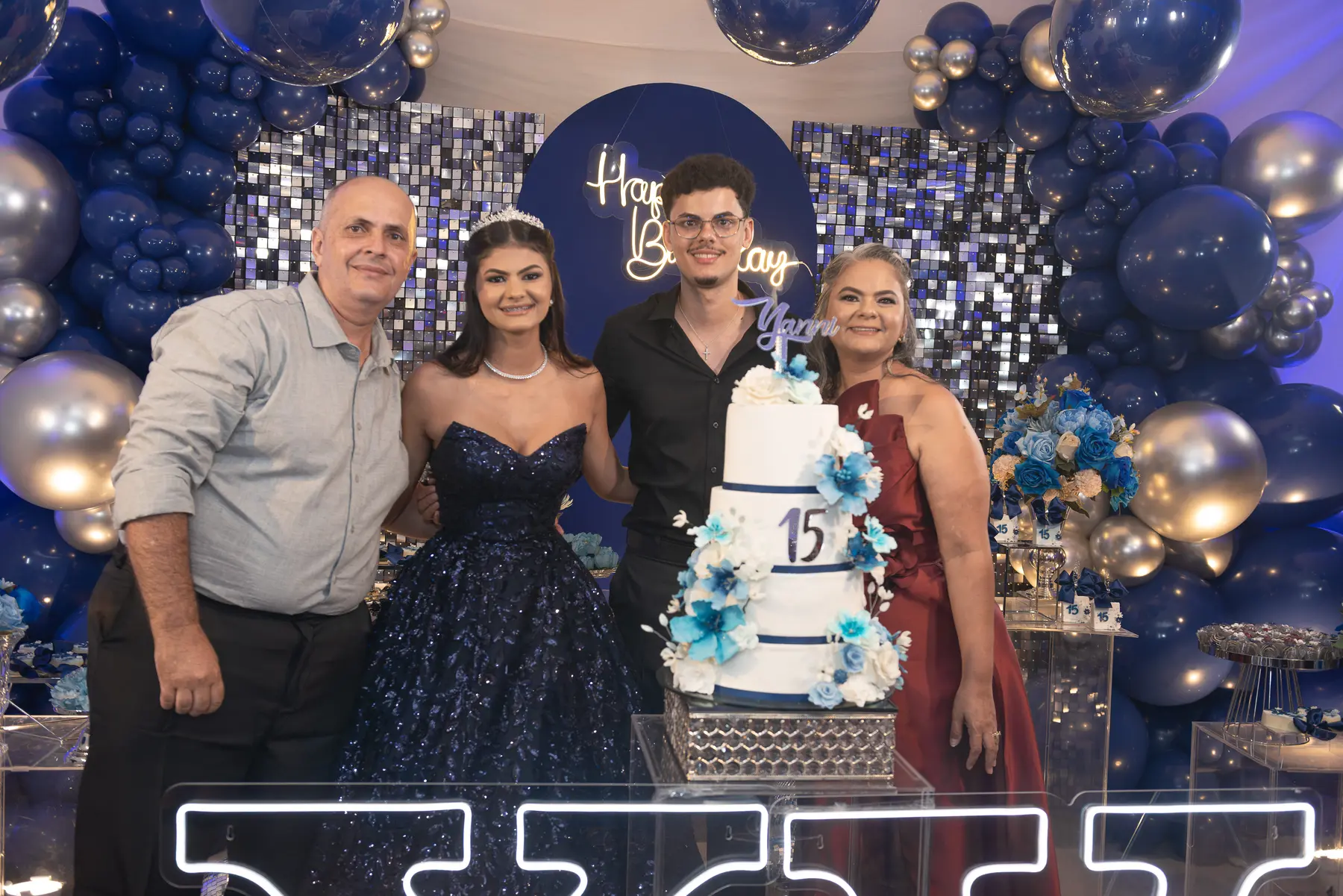 Yanni reunida com a família diante da decoração da festa de 15 anos